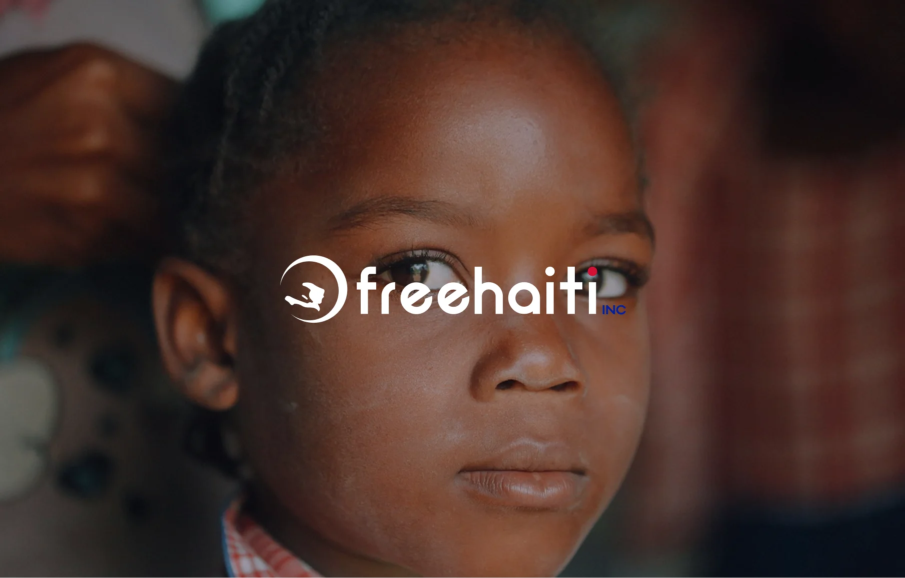 Free Haiti logo in white over a close-up portrait of a child