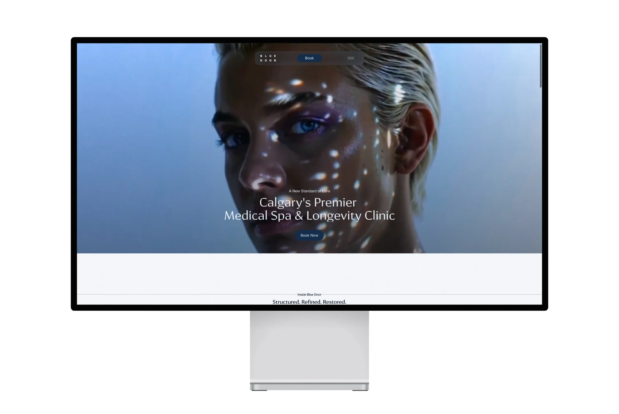 Blue Door Med homepage displayed on a desktop monitor with a beauty portrait and medical spa headline