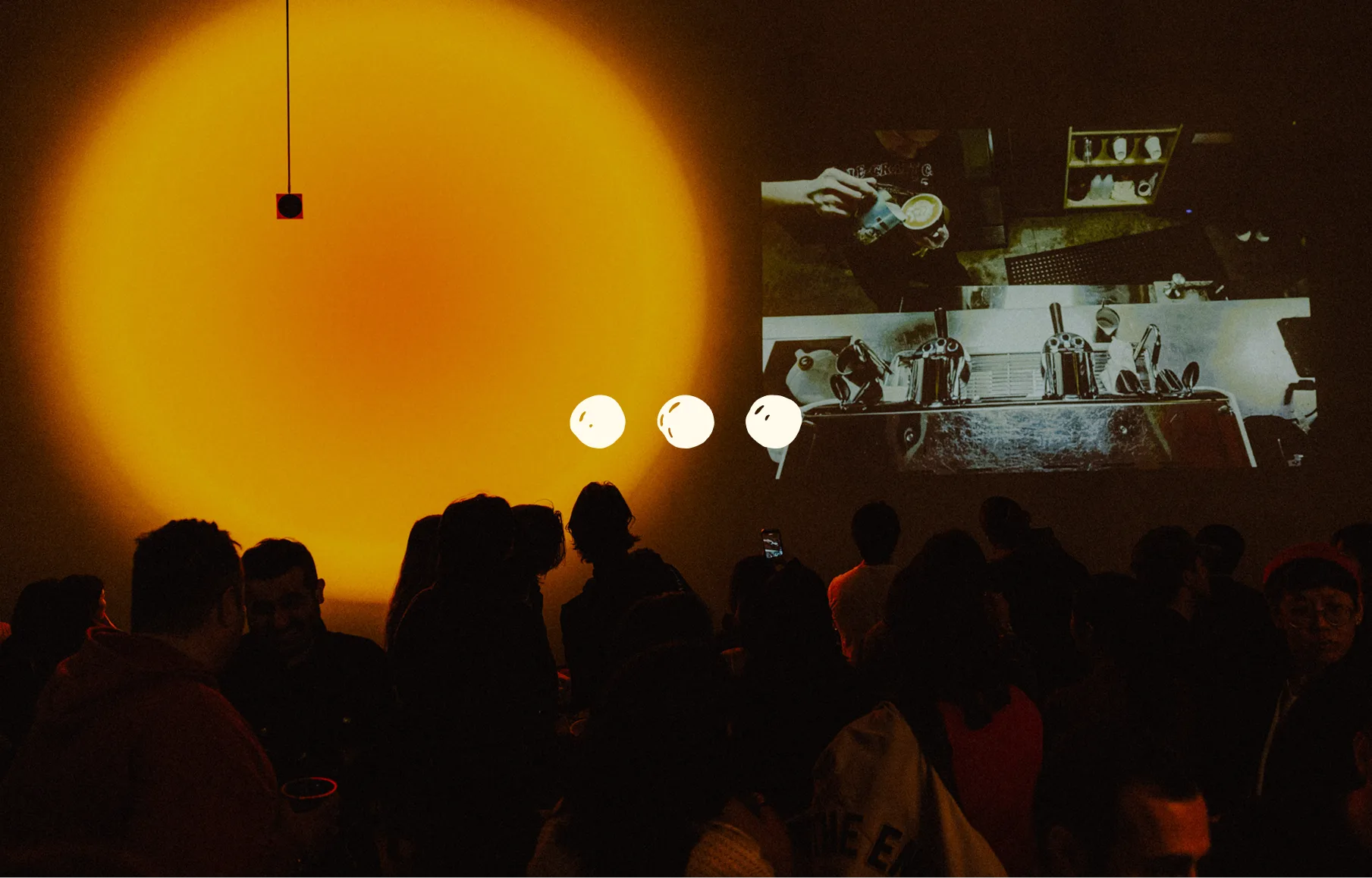 The Ellipsis three-dot mark over a warmly lit restaurant gathering.